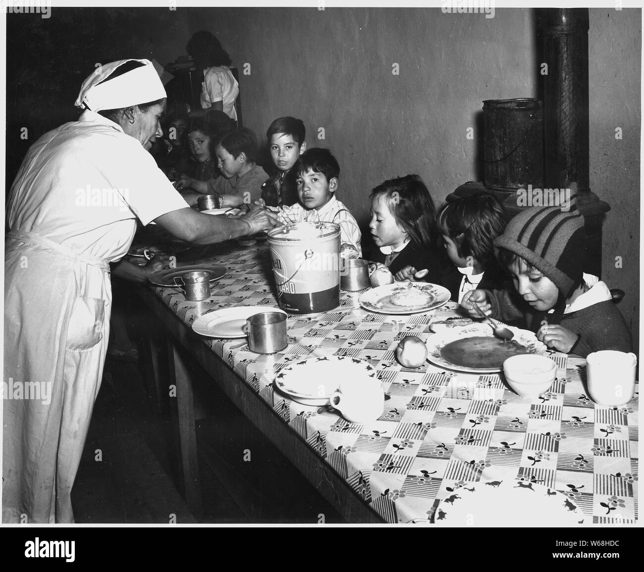 Taos County, New Mexico. The hot lunch, school at Penasco. Children pay about 1 cent daily for thi . . .; Scope and content:  Full caption reads as follows: Taos County, New Mexico. The hot lunch, school at Penasco. Children pay about 1 cent daily for this hot meal made up primarily of food from the Surplus Commodities Program, and prepared by WPA-paid cooks. Stock Photo