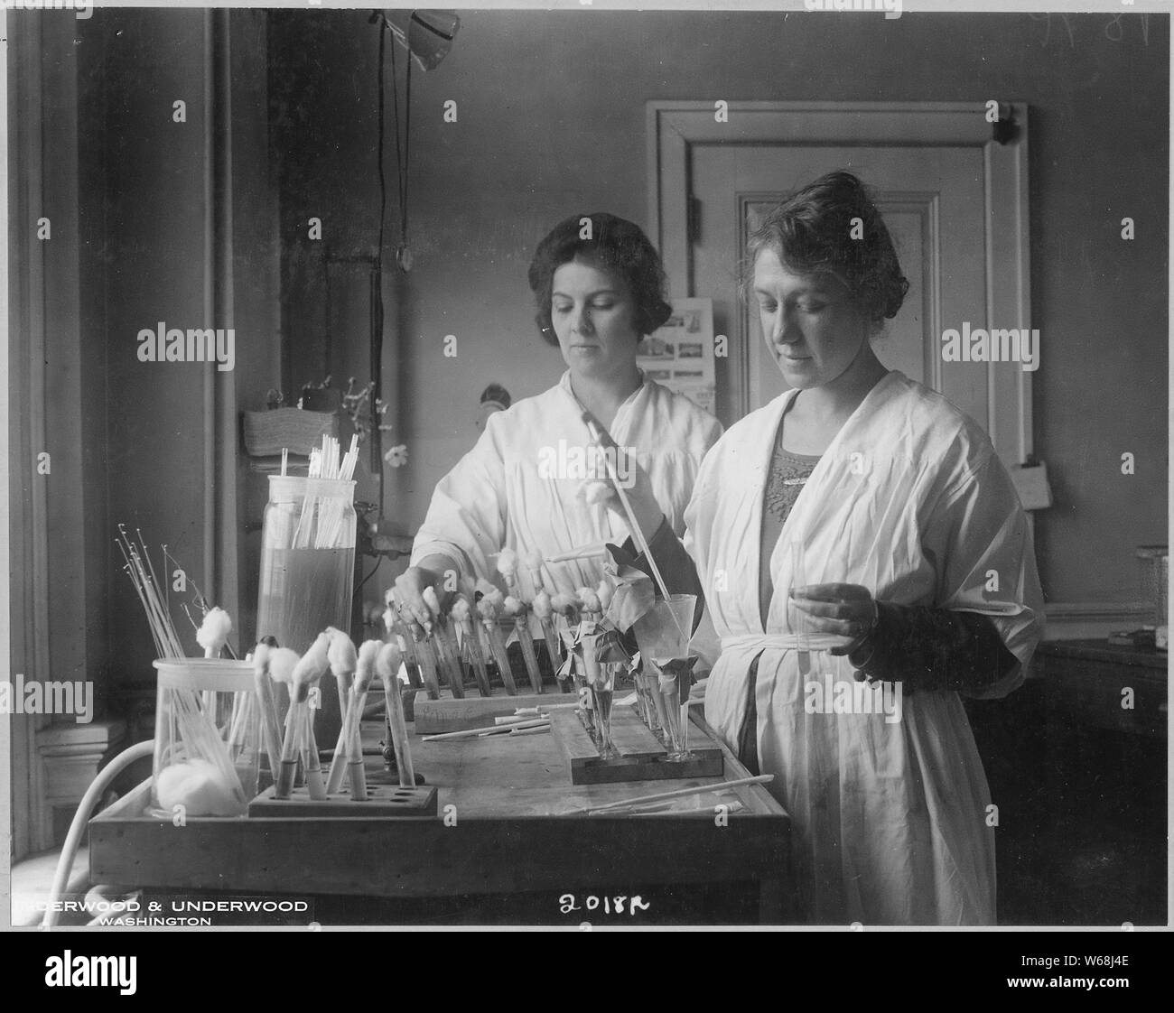 Testing antipneumoccus serum for potency. The Public Health Service keeps a close check on the commercial production of serums, vaccines, and analogous products so that physicans and patients may be assured of a safe remedy. Hygienic Laboratory. Doctor Ella Eulows (right) and laboratory assistant Sadie Carlin (left) making the tests. Stock Photo
