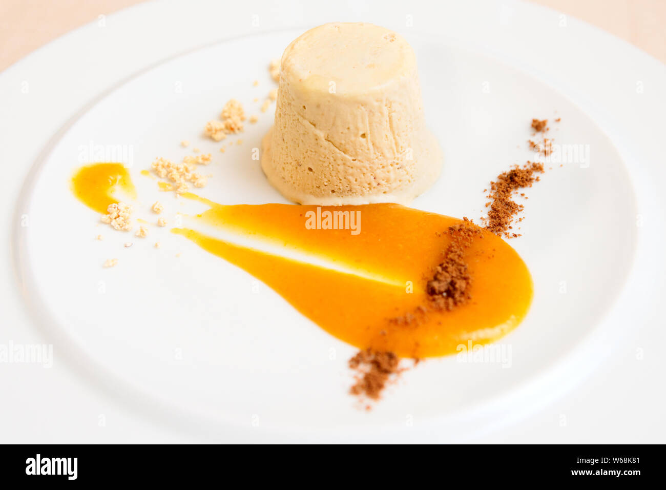 Semifreddo dessert with mango sauce in plate, close-up Stock Photo