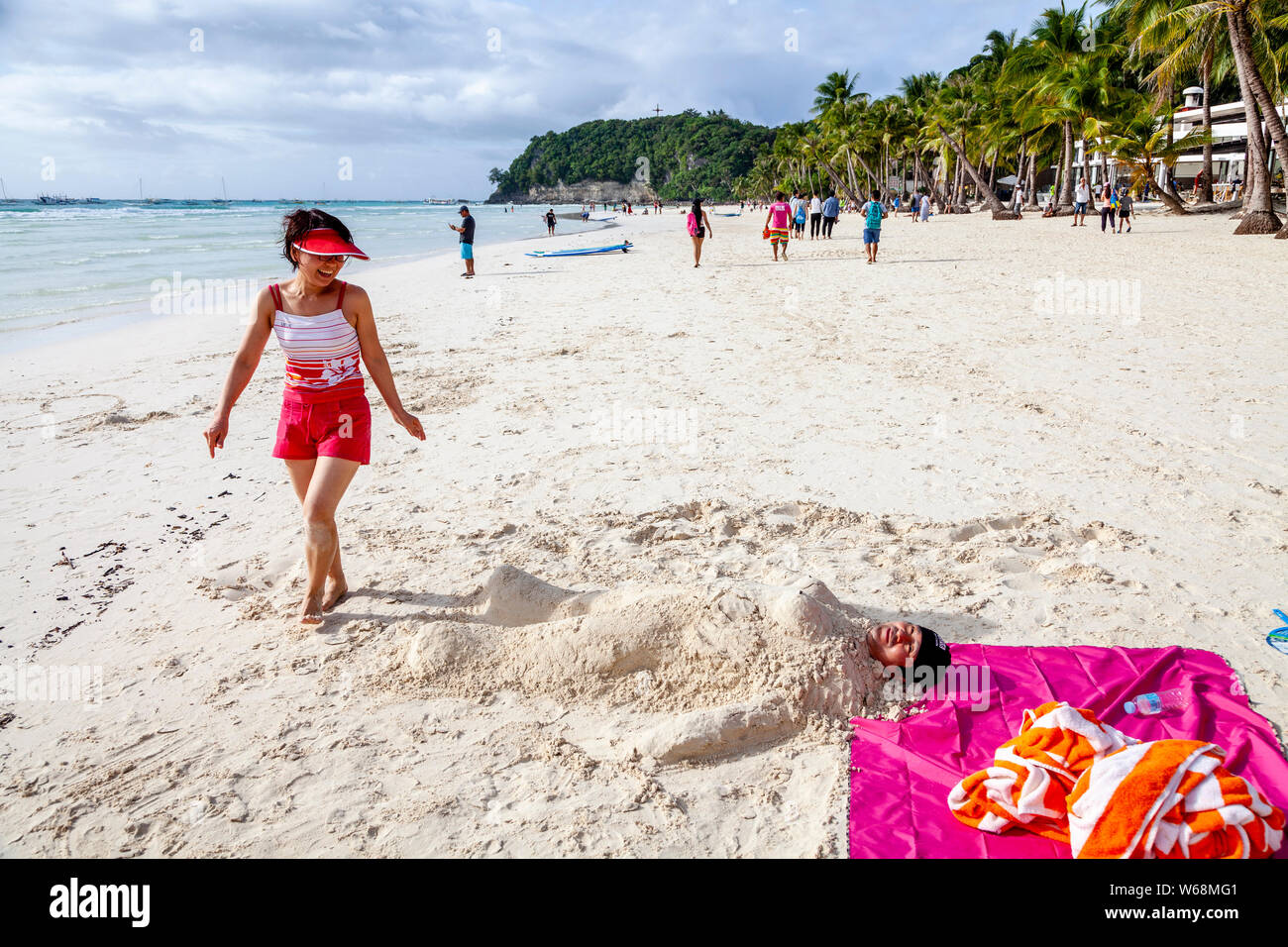 Tourists Being Covered In Sand, White Beach, Boracay, Aklan Province, The Philippines. Stock Photo
