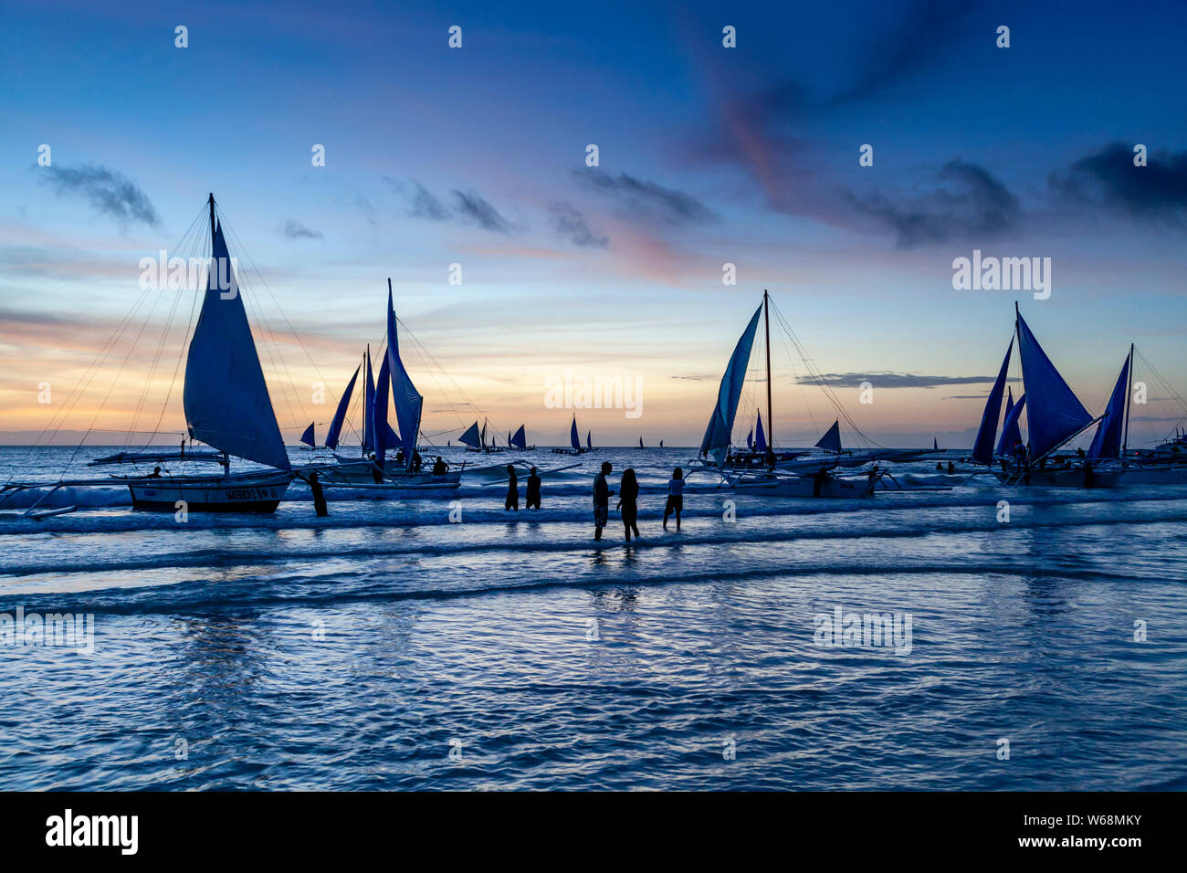 Traditional Paraws (Sailing Boats) On A Sunset Cruise off White Beach, Boracay, Aklan Province, The Philippines. Stock Photo