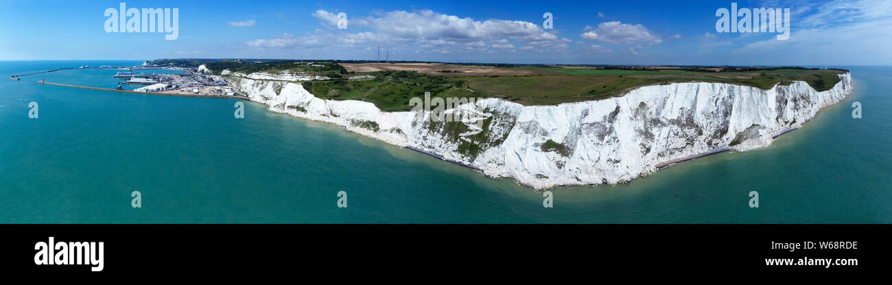 Aerial panorama of Port of Dover with ferry ships docked in passengers terminal and view over white cliffs, coastal countryside on a sunny summer day, Stock Photo