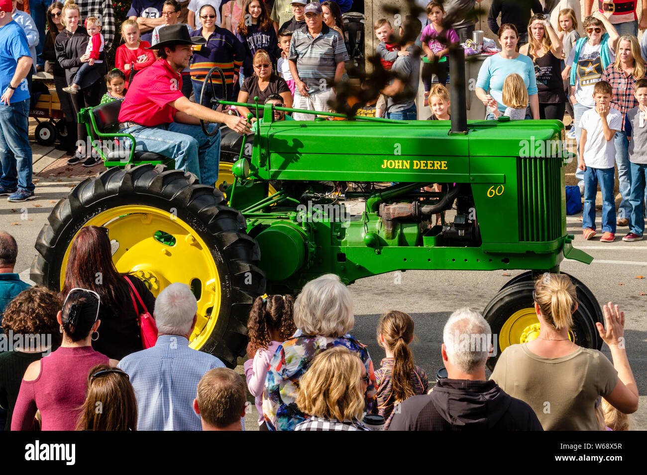 Bright green antique John Deere farm tractor being driven in annual Christmas