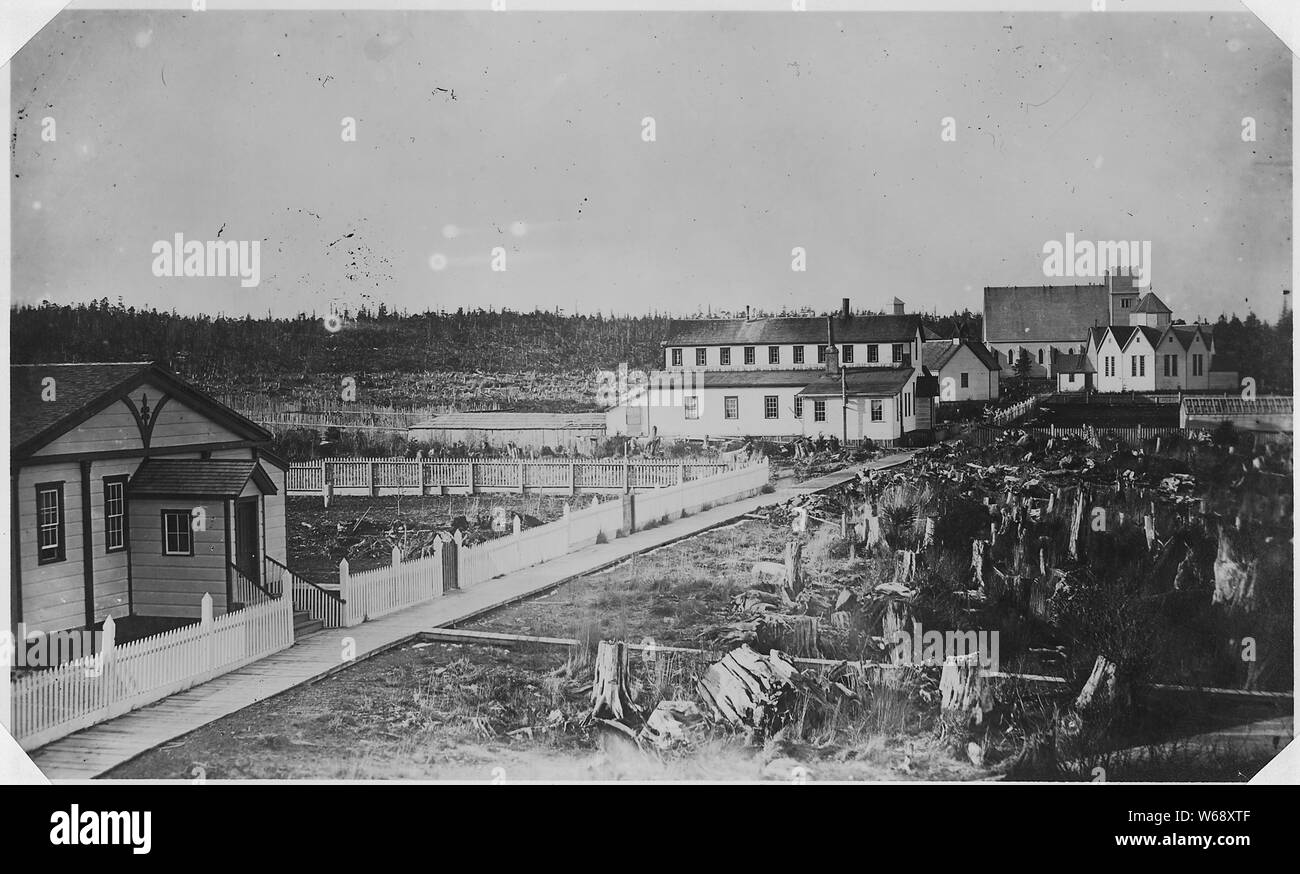 View of Metlakahtla, Alaska, street.; Scope and content:  Left to right: William Duncan's house (front left) ; Mission Building (center of photograph) ; school, church and town hall. Stock Photo