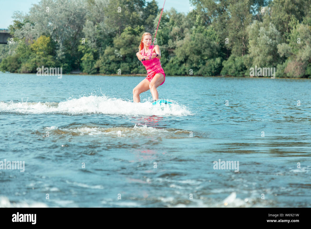 Young active beautiful blonde woman riding a wakeboard Stock Photo