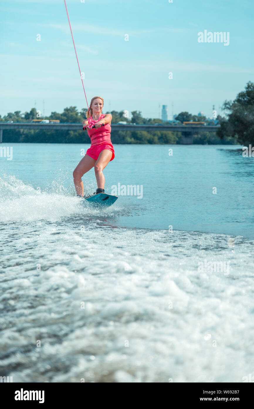 Woman riding a wakeboard on a local river Stock Photo