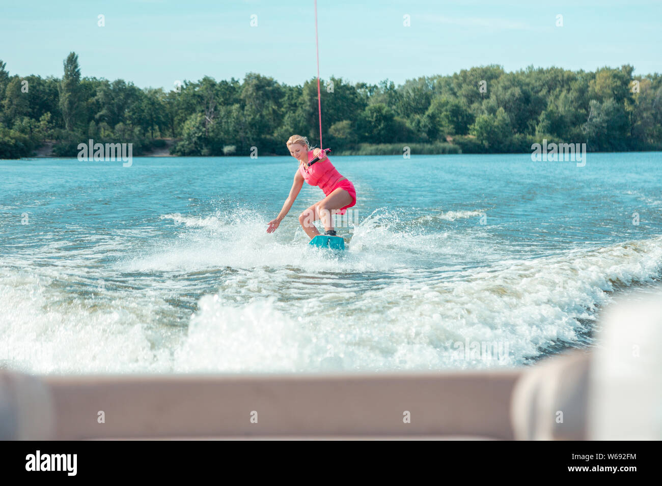 Sporty woman riding a wakeboard and performing tricks Stock Photo