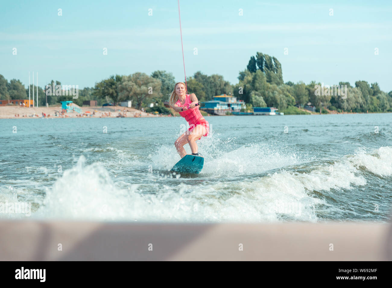 Beautiful active young blonde woman riding a wakeboard Stock Photo