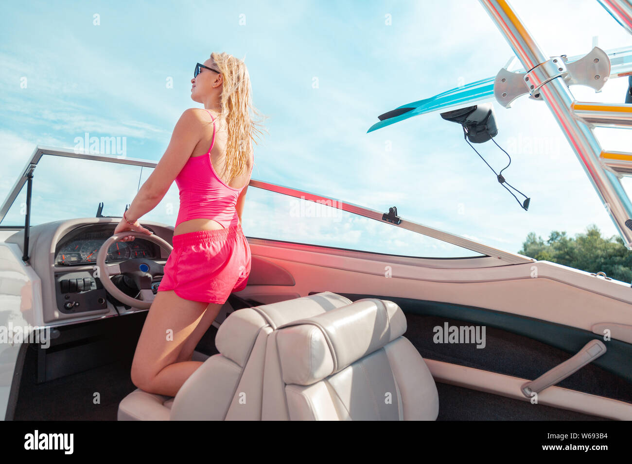 Fit girl in pink shorts steering a yacht Stock Photo Alamy