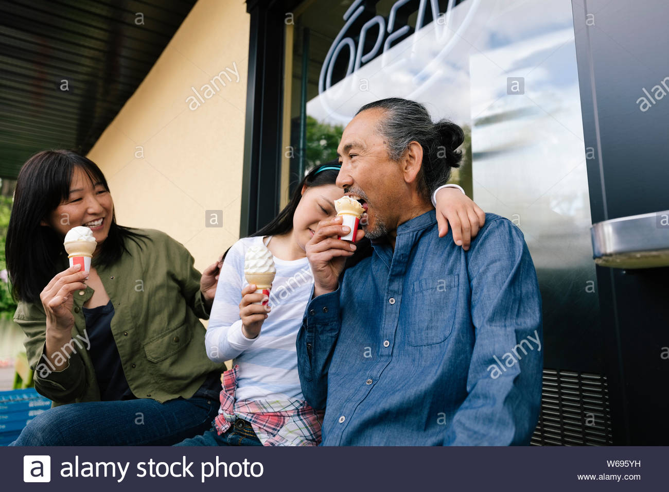 Happy family eating ice cream outside drivein Stock Photo Alamy