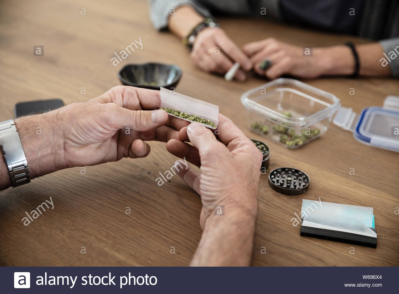 Senior couple rolling marijuana joints at dining table Stock Photo Alamy