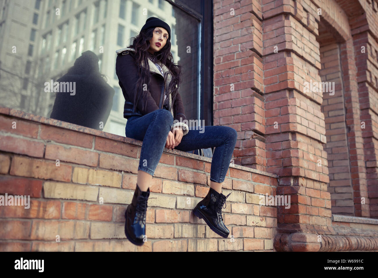 Outdoor lifestyle portrait of pretty young girl, wearing hipster swag  grunge style on urban background. Wearing hat and jeans with backpack.  Spring fa Stock Photo - Alamy