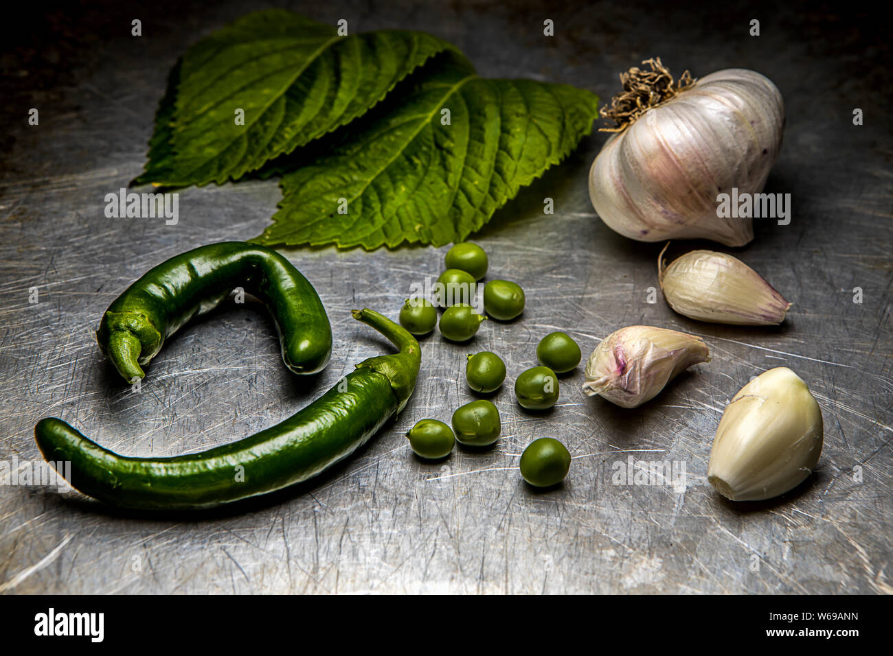 A close up studio image of an assortment of vegetables such as garlic, lettuce, peas, and peppers. Stock Photo