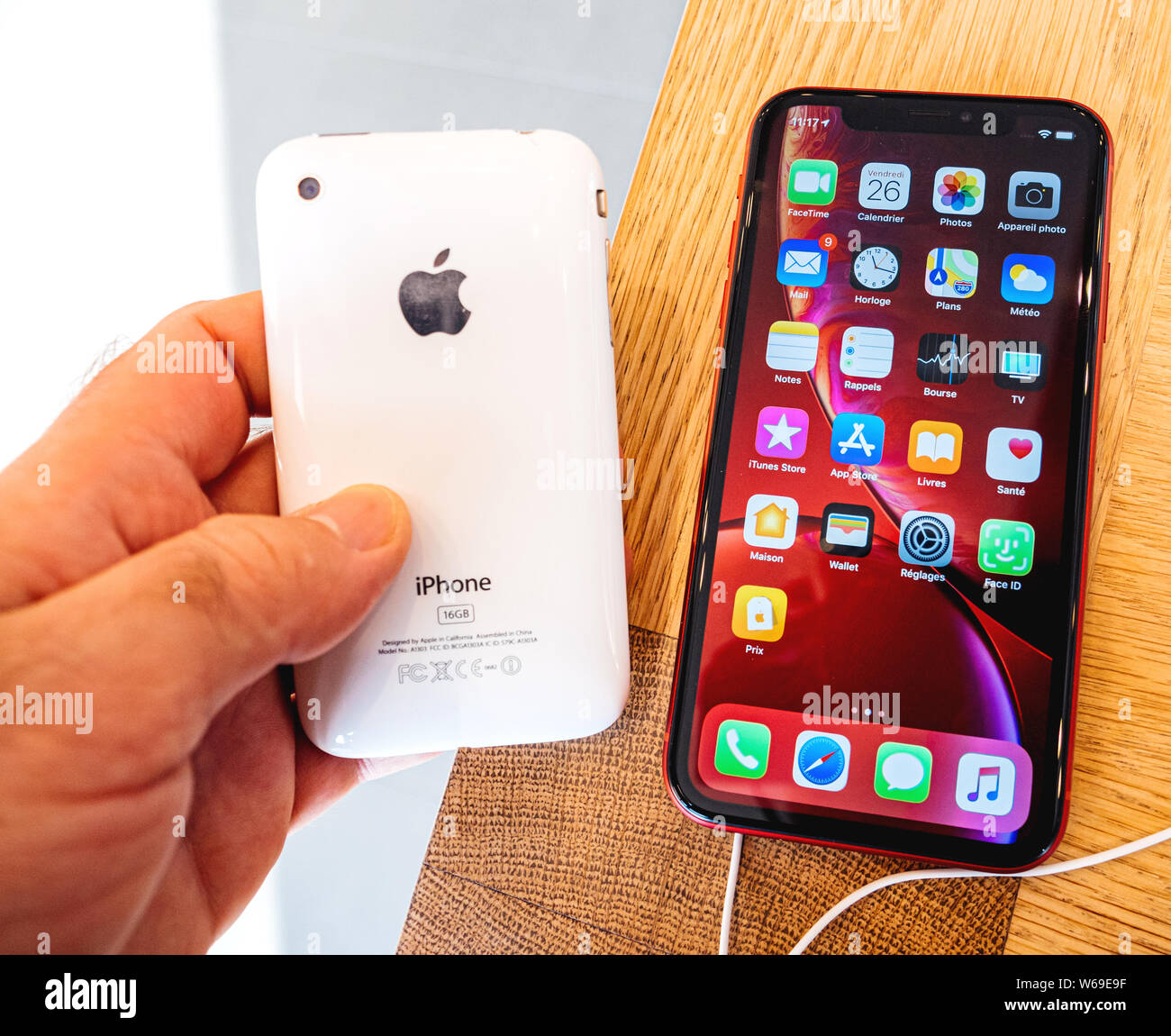 Paris, France - Oct 26, 2018: Man hand holding latest red iPhone XR  smartphone next to 3GS vintage modern during launch day manufactured by  Apple Computers Stock Photo - Alamy