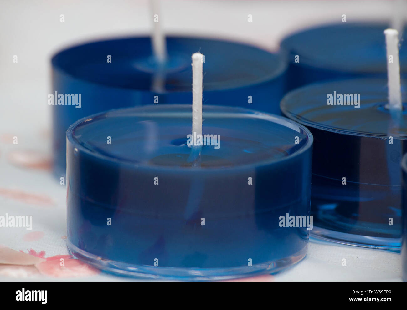 Candle making tealights, these small blue tealight candles are in liquid  form on a candlemaker's bench. White wicks are in the liquid wax cups Stock  Photo - Alamy