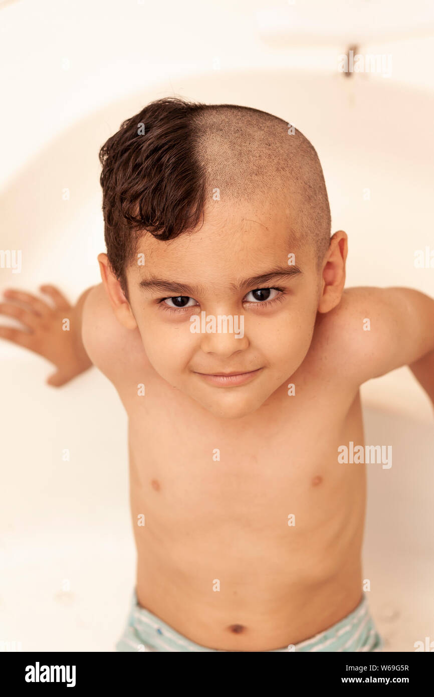 Portrait of a little middle eastern boy at the bathroom. 6-year-old pretty  kid with half-cut hair at home Stock Photo - Alamy