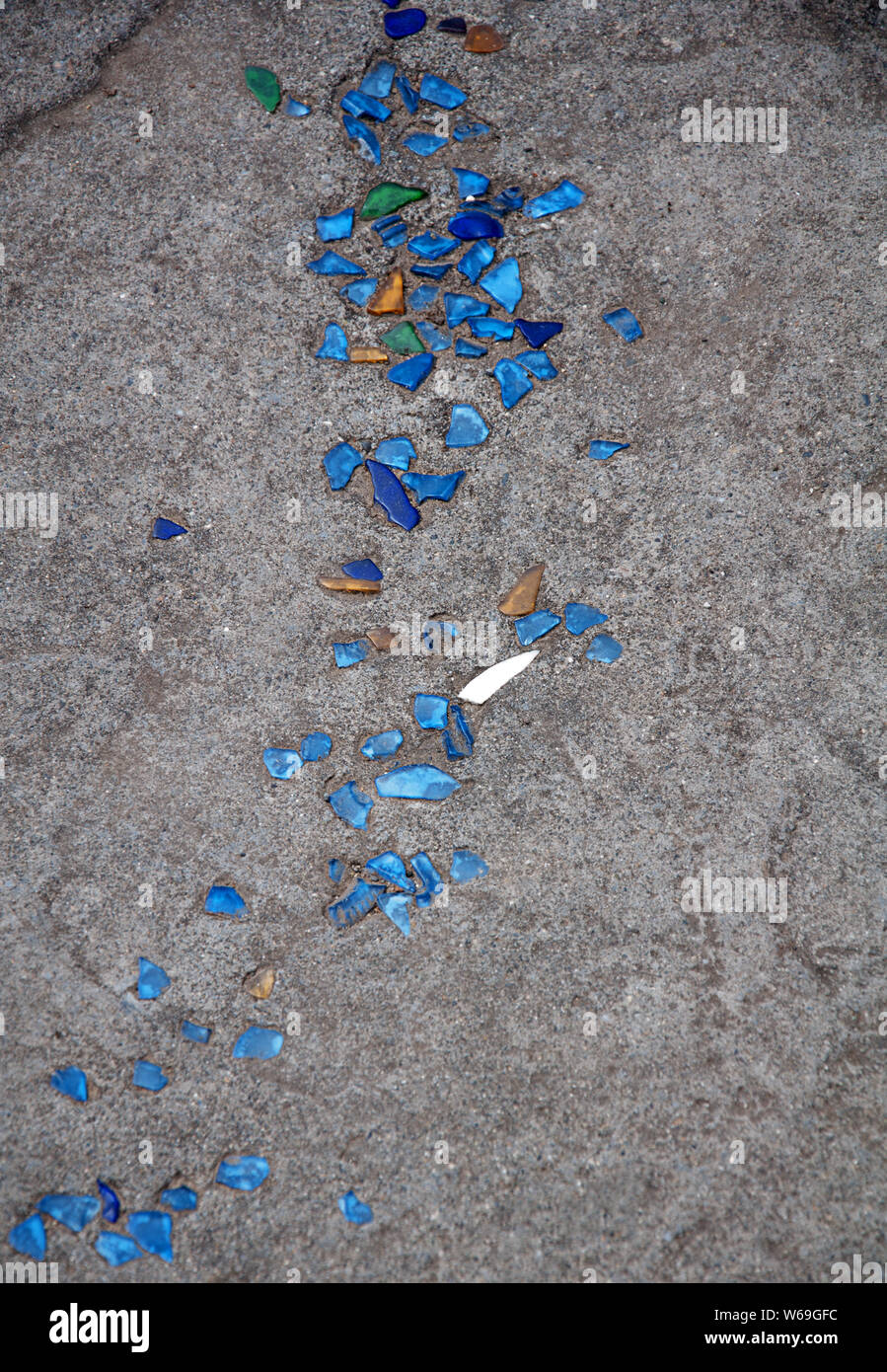 Seaglass embedded in concrete in this vertical image for great texture and interest for a graphic design element.  Blues and greens sea glass. Stock Photo