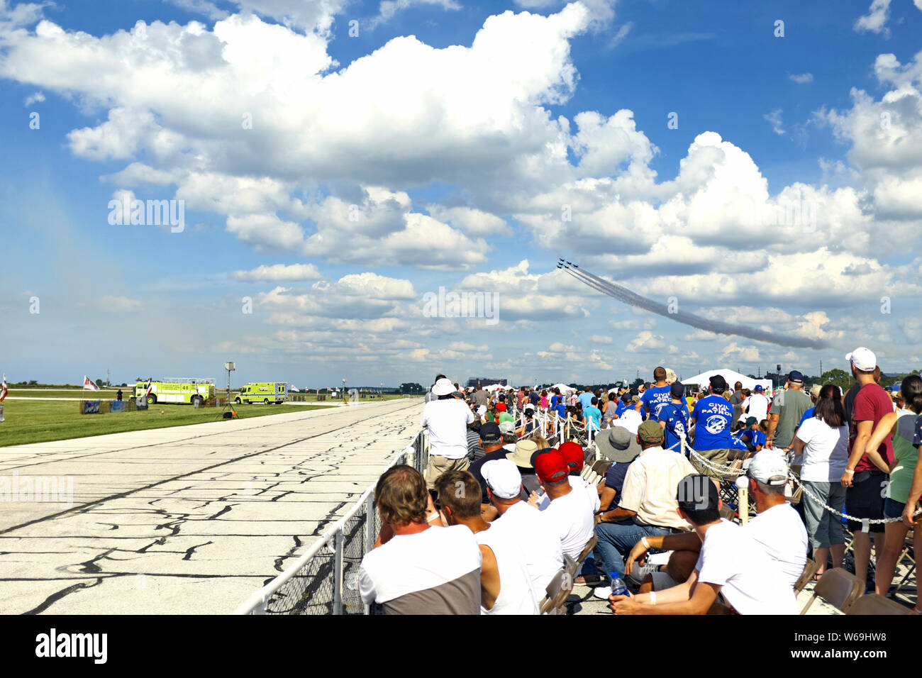 People watch U.S. Navy Blue Angels fly in formation over the crowd at the 2018 Cleveland National Air Show in Cleveland, Ohio, USA. Stock Photo