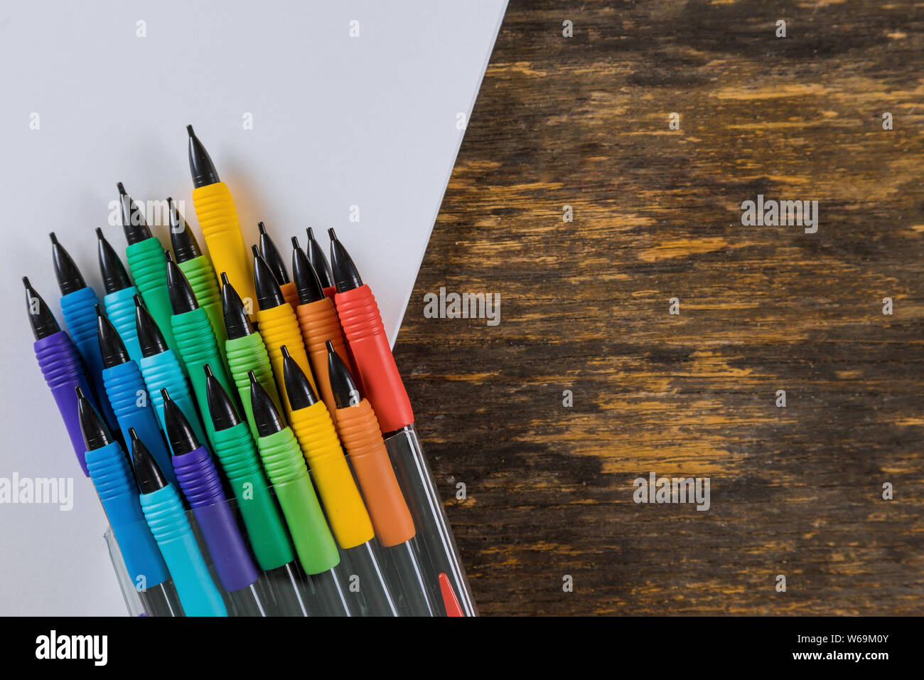 Pencils and drawing or sketch pad on wooden background. School