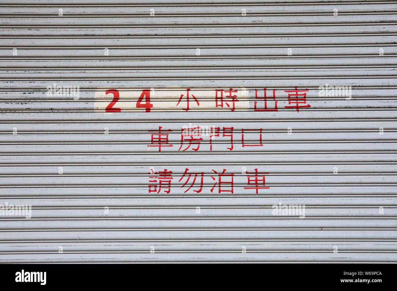 Red writing with Chinese characters on roller shutter door in Kennedy Town, Hong Kong Stock Photo