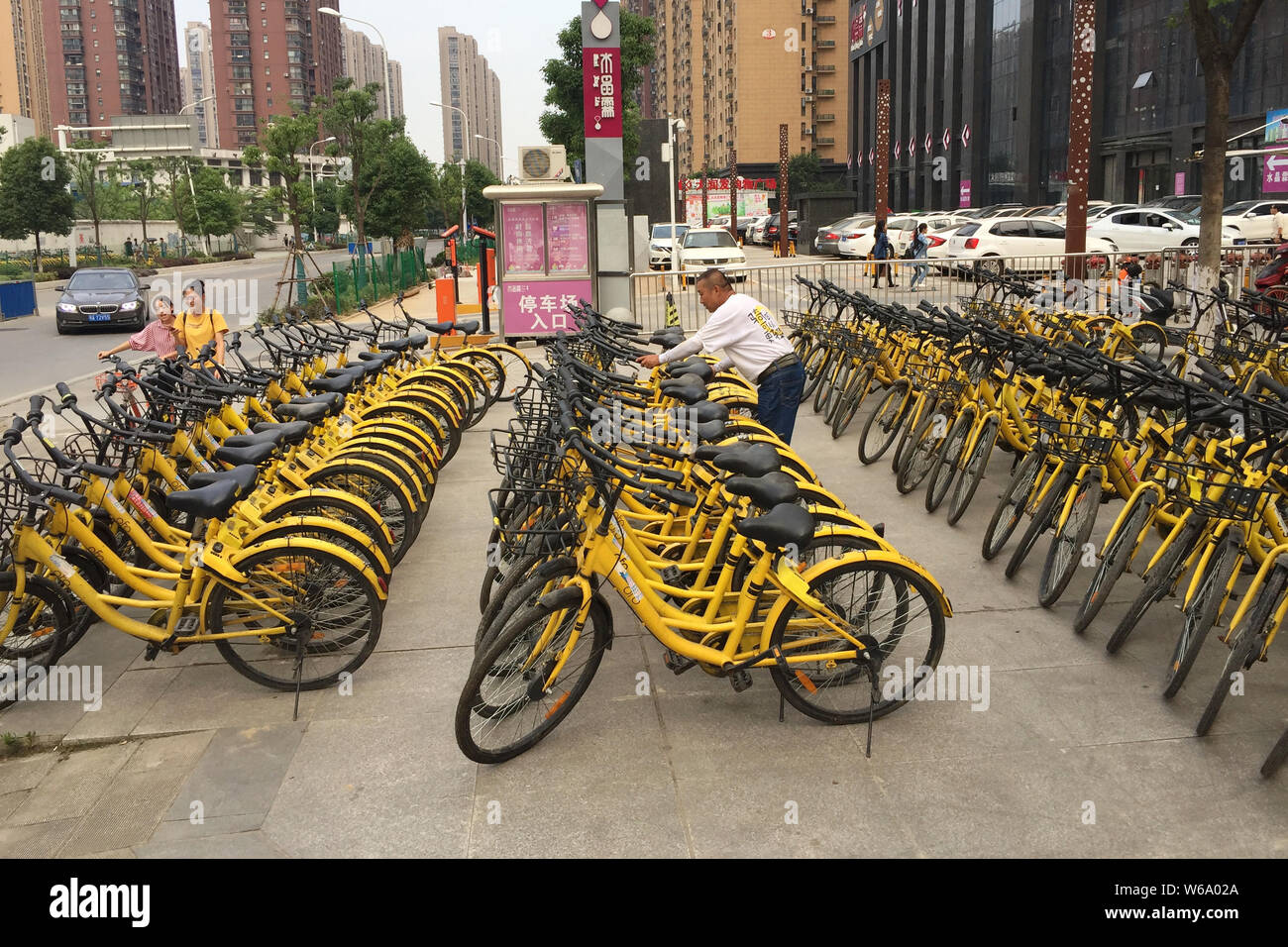 FILE A Chinese worker displays bicycles of Chinese bike sharing service ofo near a subway station in Wuhan city central China s Hubei province 16 Stock Photo Alamy