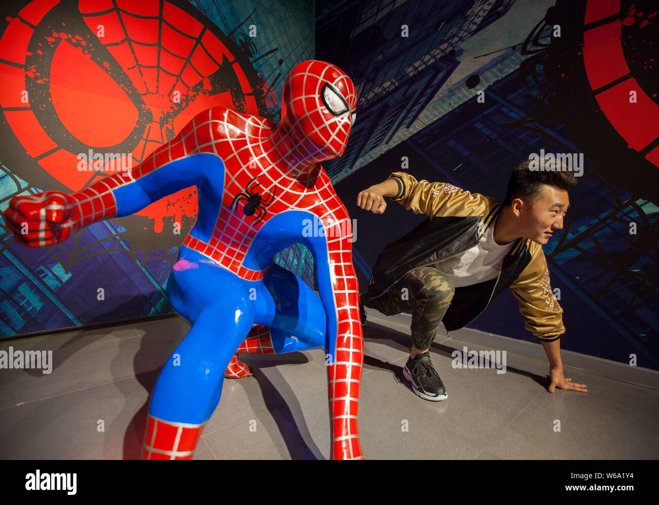 A Visitor Poses For Photos With A Wax Figure Of Spiderman In The