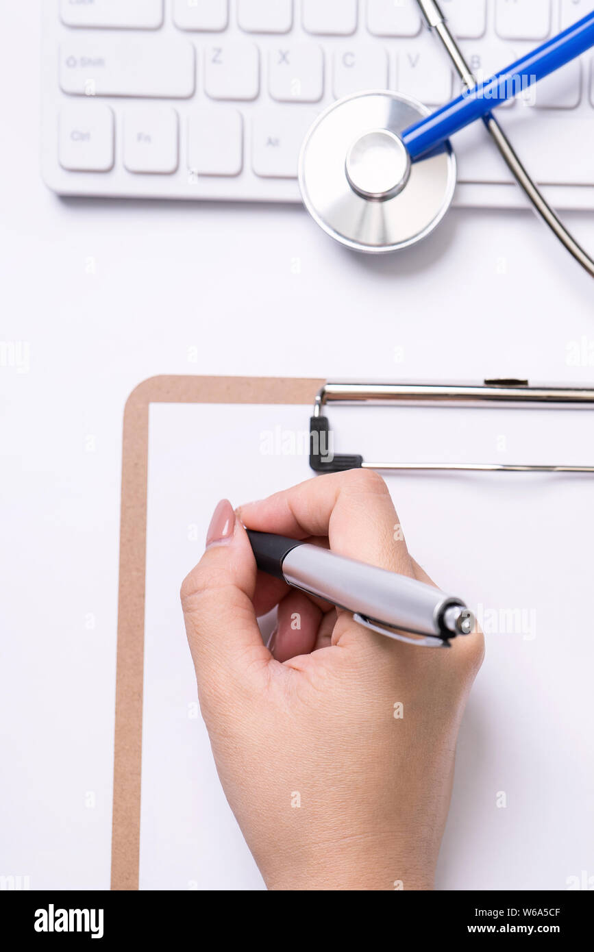 Female doctor writing a medical record case over clipboard on white ...