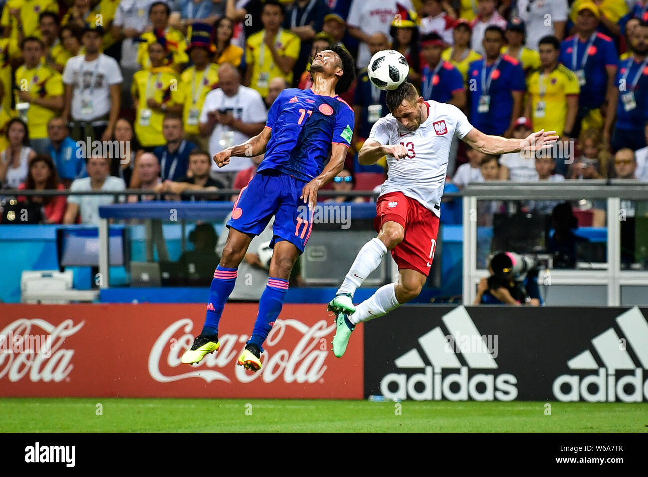 Juan Cuadrado of Colombia, left, and Maciej Rybus of Poland jump for a header in their Group H match during the FIFA World Cup 2018 in Kazan, Russia, Stock Photo