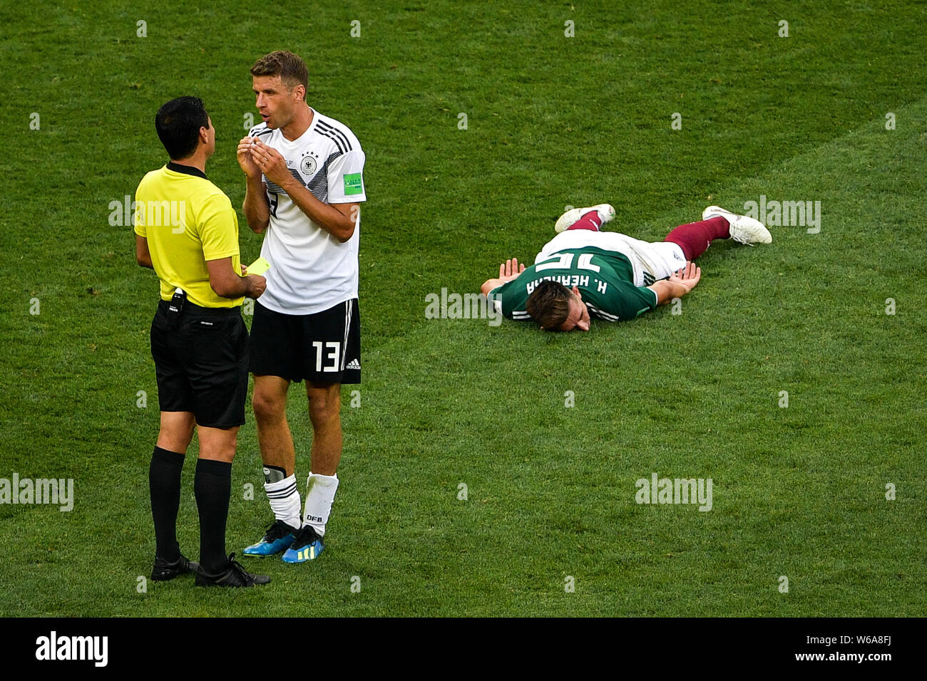 Thomas Muller (Mueller) of Germany talks with referee as Hector Herrera of Mexico lies on the ground in their Group F match during the 2018 FIFA World Stock Photo