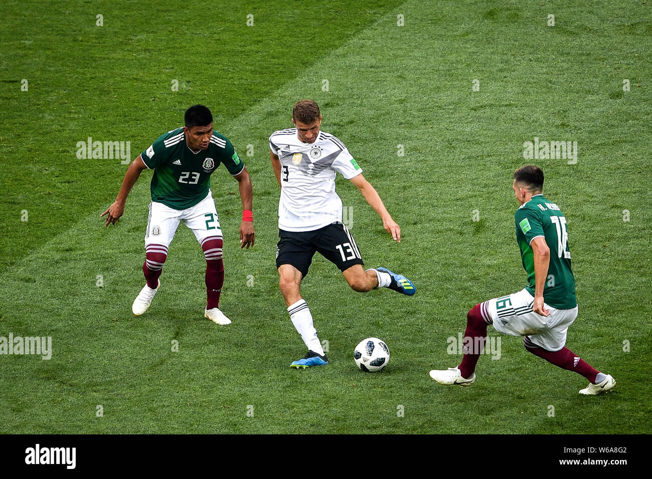 Thomas Muller (Mueller) of Germany, center,  passes the ball against Jesus Gallardo and Hector Herrera of Mexico in their Group F match during the 201 Stock Photo