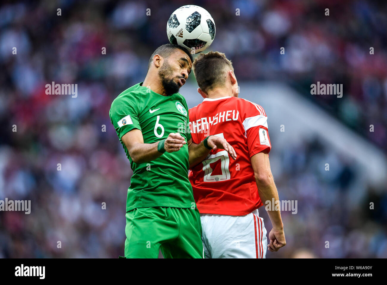 Mohammed Al-Breik of Saudi Arabia, left, heads the ball against Denis Cheryshev of Russia in their Group A match during the 2018 FIFA World Cup in Mos Stock Photo