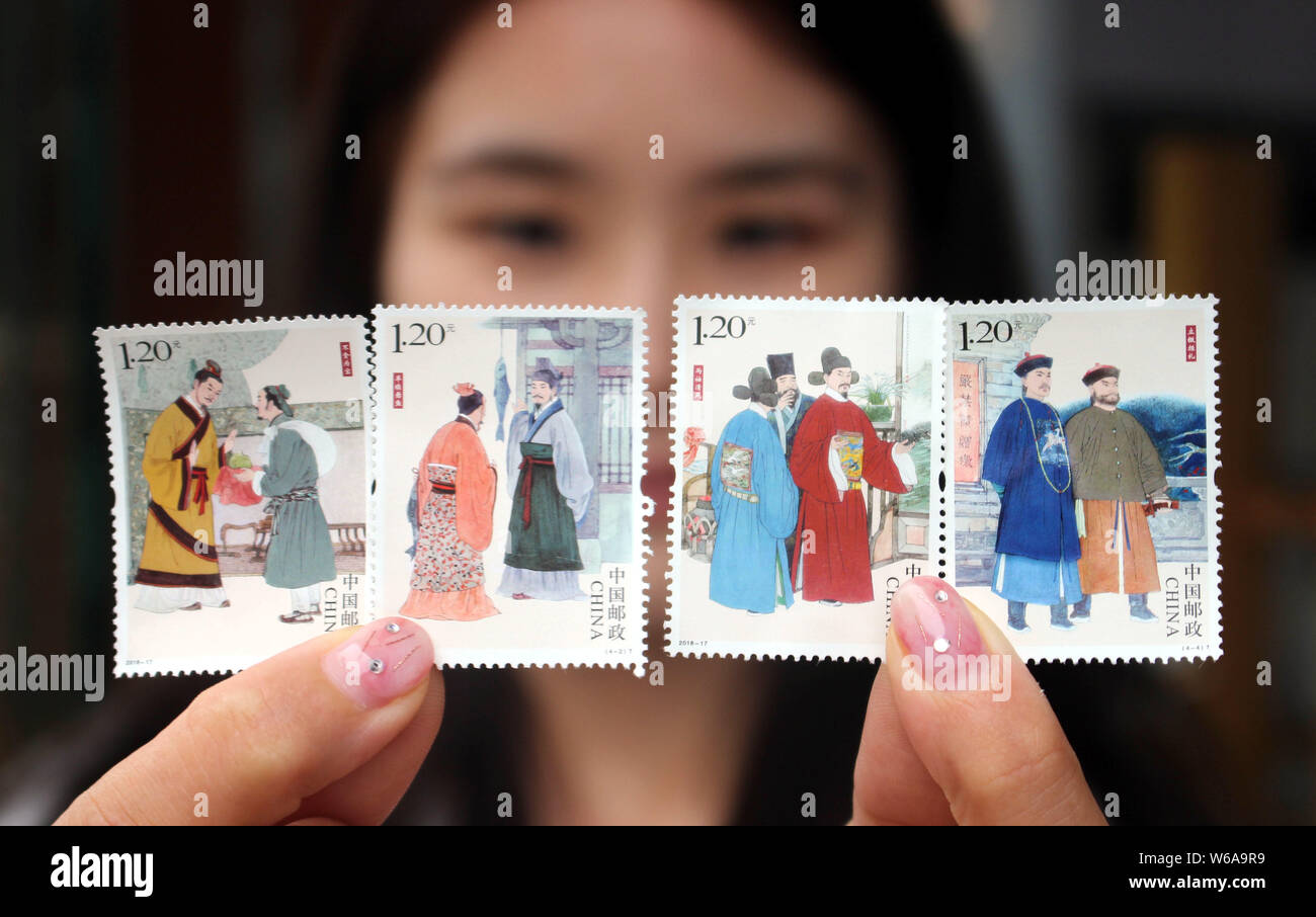 A Chinese stamp collector shows stamps from the stamp set with the