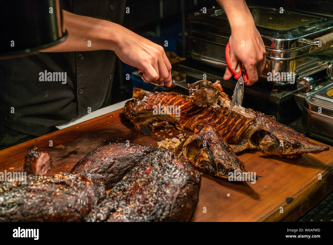 Chef hands using BBQ tools and cutting grilled fish Stock Photo