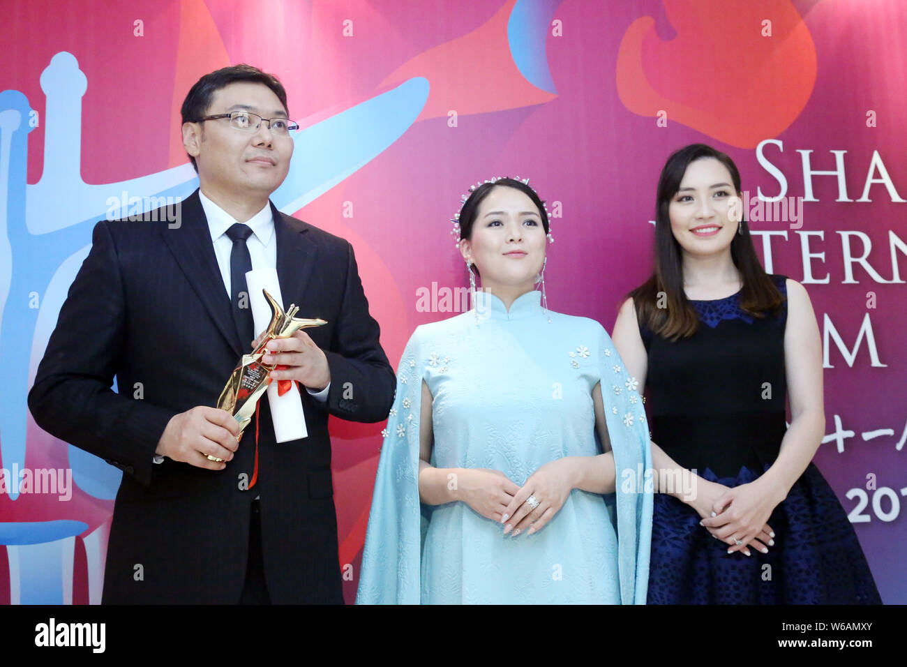 Batbayar Chogsom, left, director of 'Out of Paradise', wins the Best Feature Film award at the awarding ceremony of the 21st Golden Goblet Awards duri Stock Photo