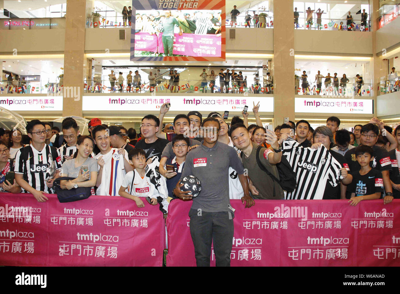 Former Dutch football player Edgar Davids, front, poses for photos with fans during a promotional event for Tuen Mun Town Plaza shopping mall in Hong Stock Photo