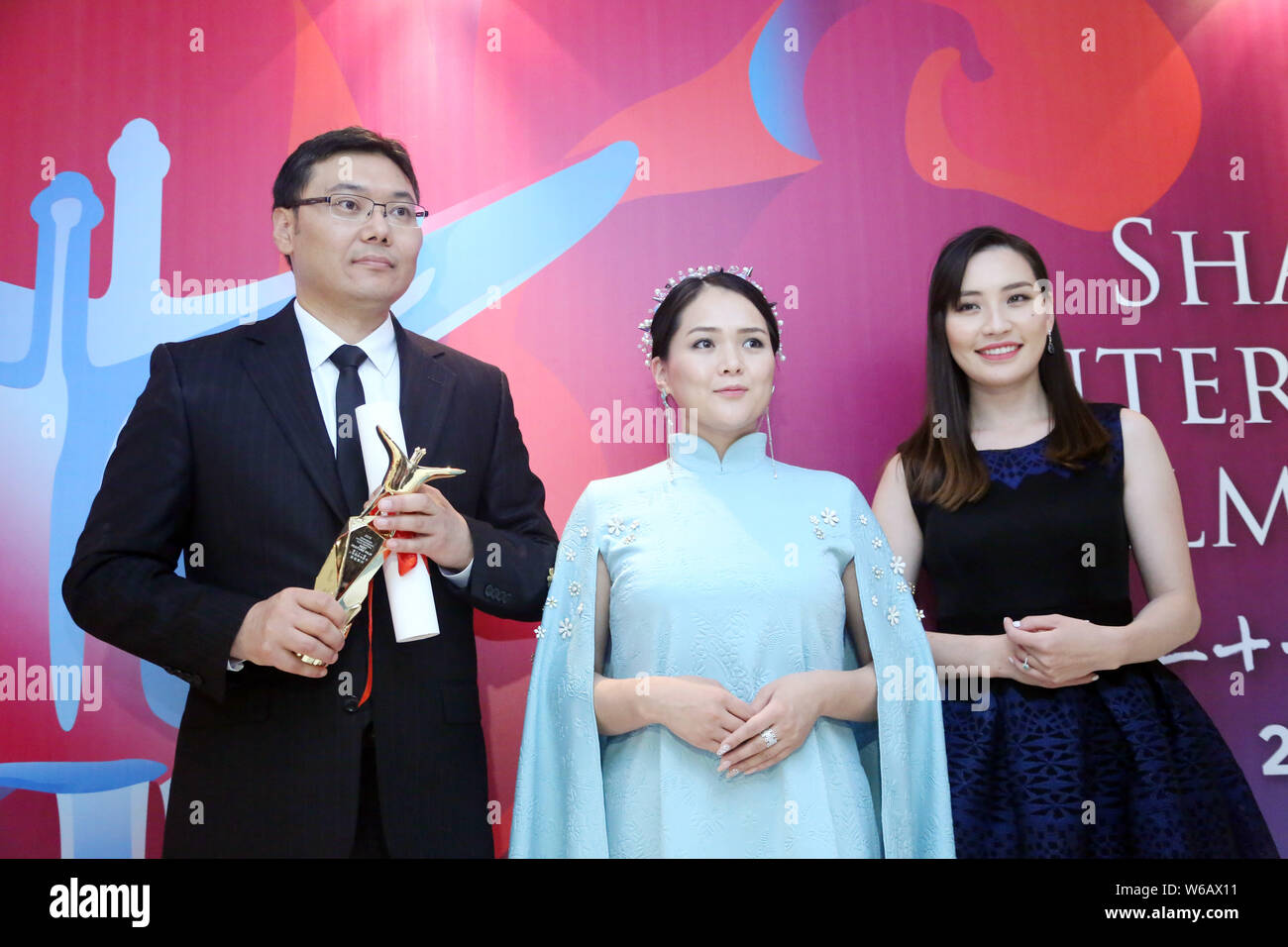 Batbayar Chogsom, left, director of 'Out of Paradise', wins the Best Feature Film award at the awarding ceremony of the 21st Golden Goblet Awards duri Stock Photo