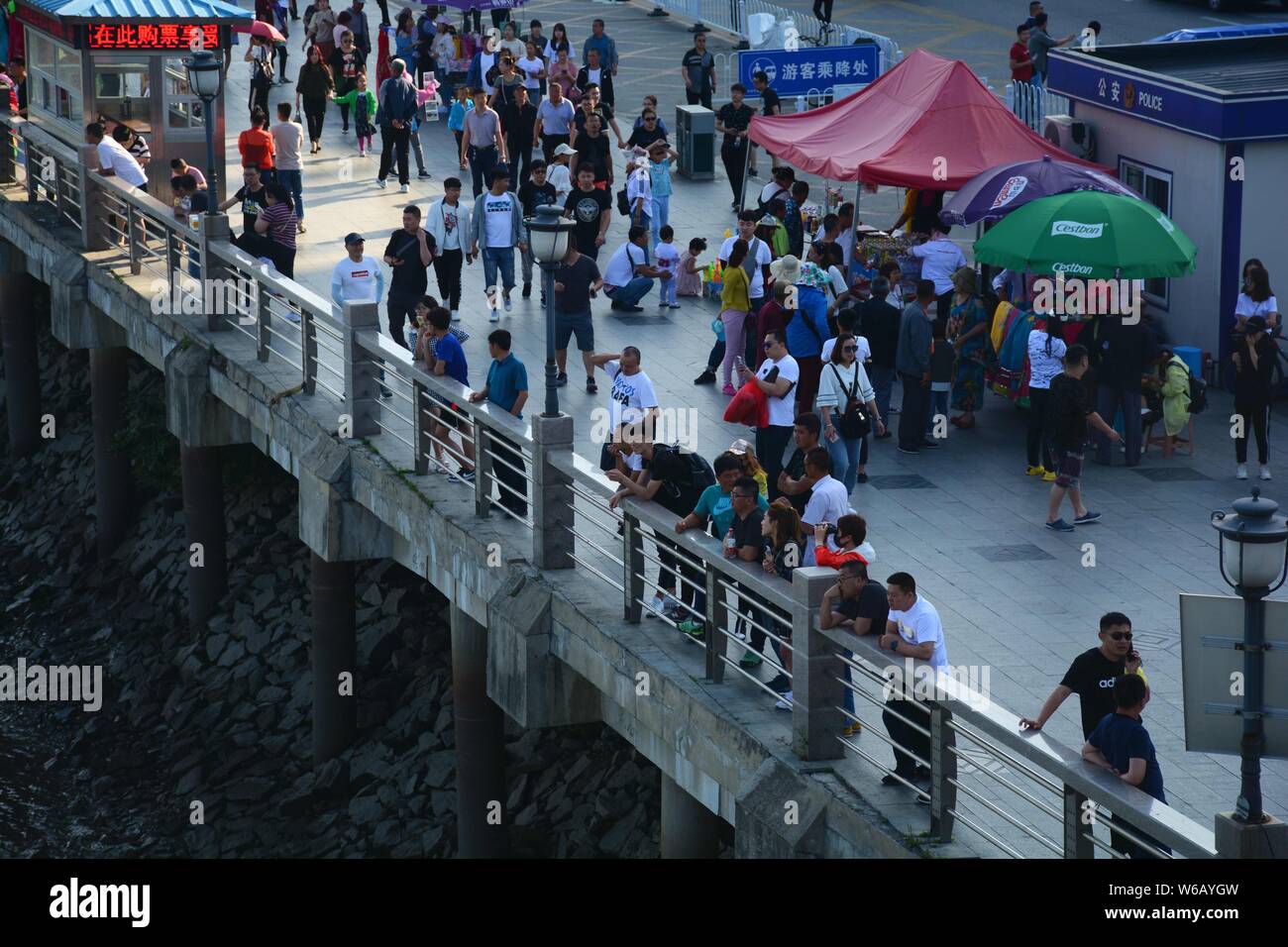 Tourists look far into the distance over Sinuiju of North Korea on the other side of Yalu River, also called the Amrok River or Amnok River, on the bo Stock Photo