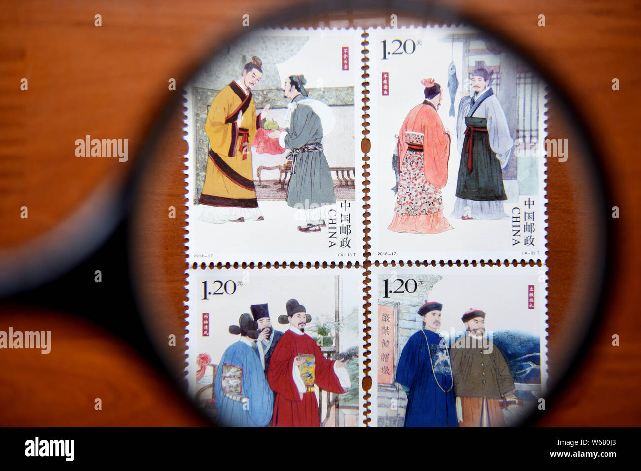 A Chinese stamp collector shows stamps from the stamp set with the