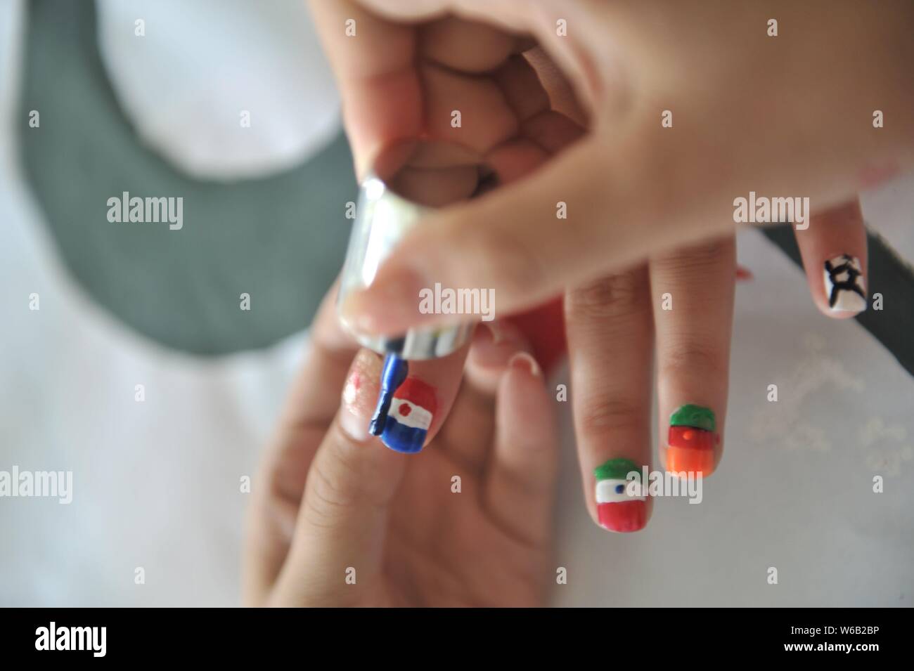 A female football fan shows her nail art design inspired by the 2018 FIFA World Cup in Liaocheng city, east China's Shandong province, 11 June 2018. Stock Photo
