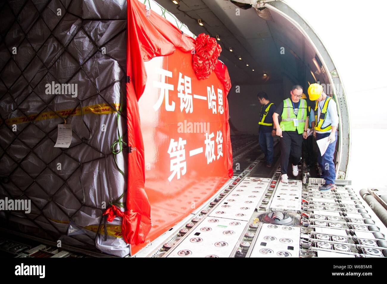 Chinese ground crew members load parcels onto a Boeing 747-400 Freighter jet plane of Atlas Air before it heads for Germany's Frankfurt-Hahn Airport a Stock Photo