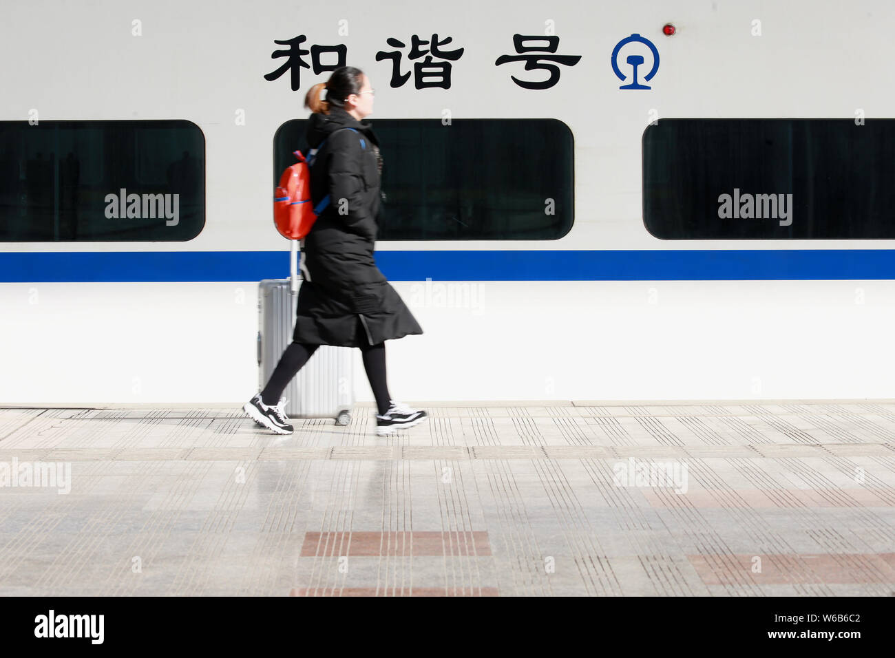 --FILE--A Chinese passenger pulls her luggage to catch up her train at the Nantong Railway Station in Nantong city, east China's Jiangsu province, 11 Stock Photo