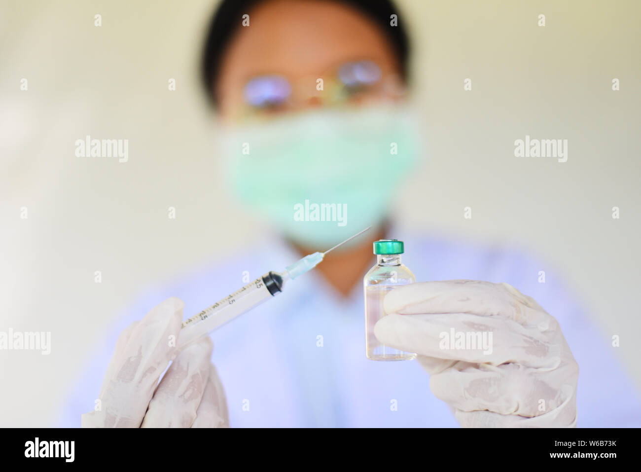 Syringe medication injection and needle in hand nurse asian for giving