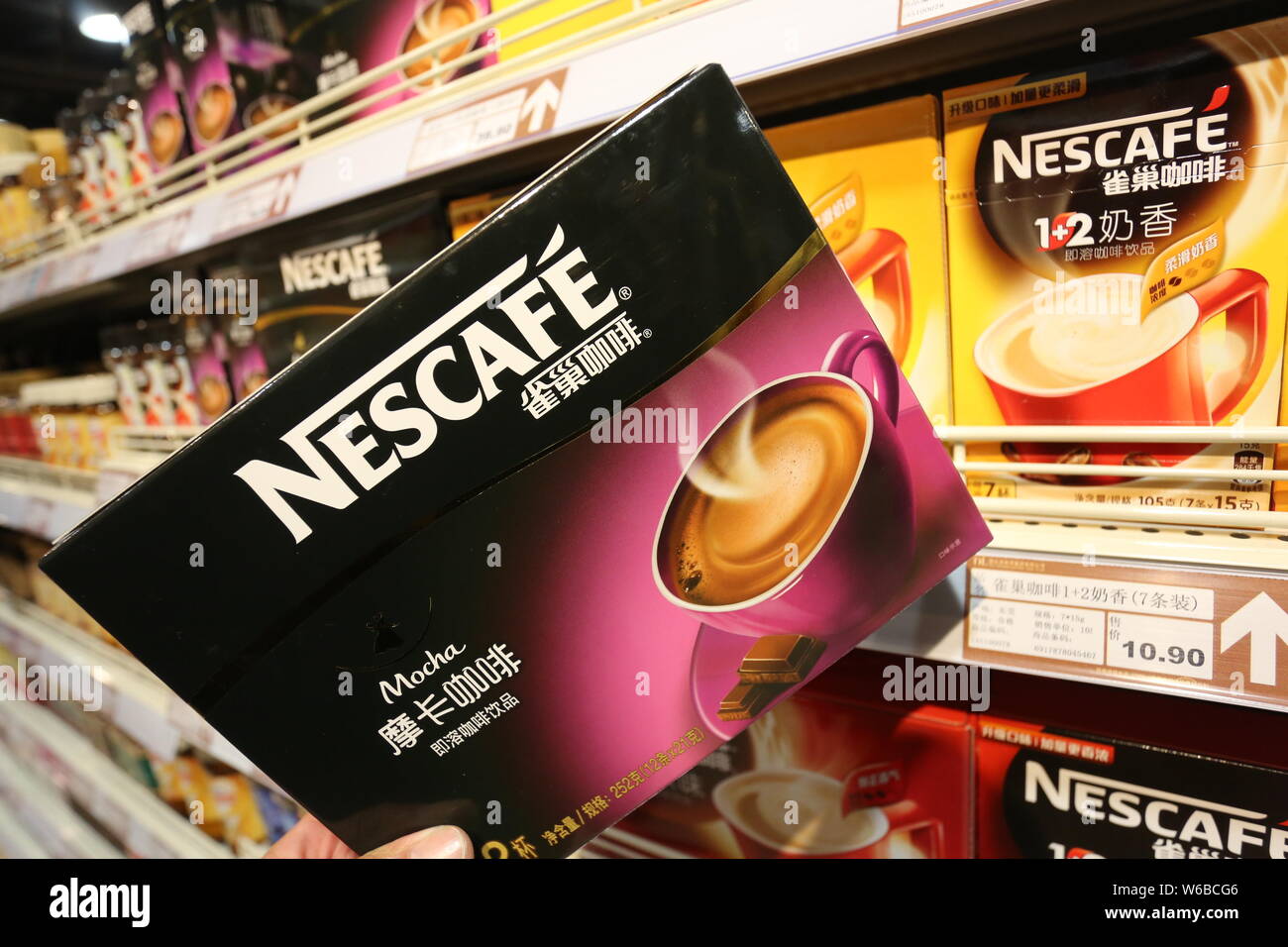--FILE--A customer shops for a carton of Nescafe coffee of Nestle at a supermarket in Xuchang city, central China's Henan province, 16 November 2014. Stock Photo