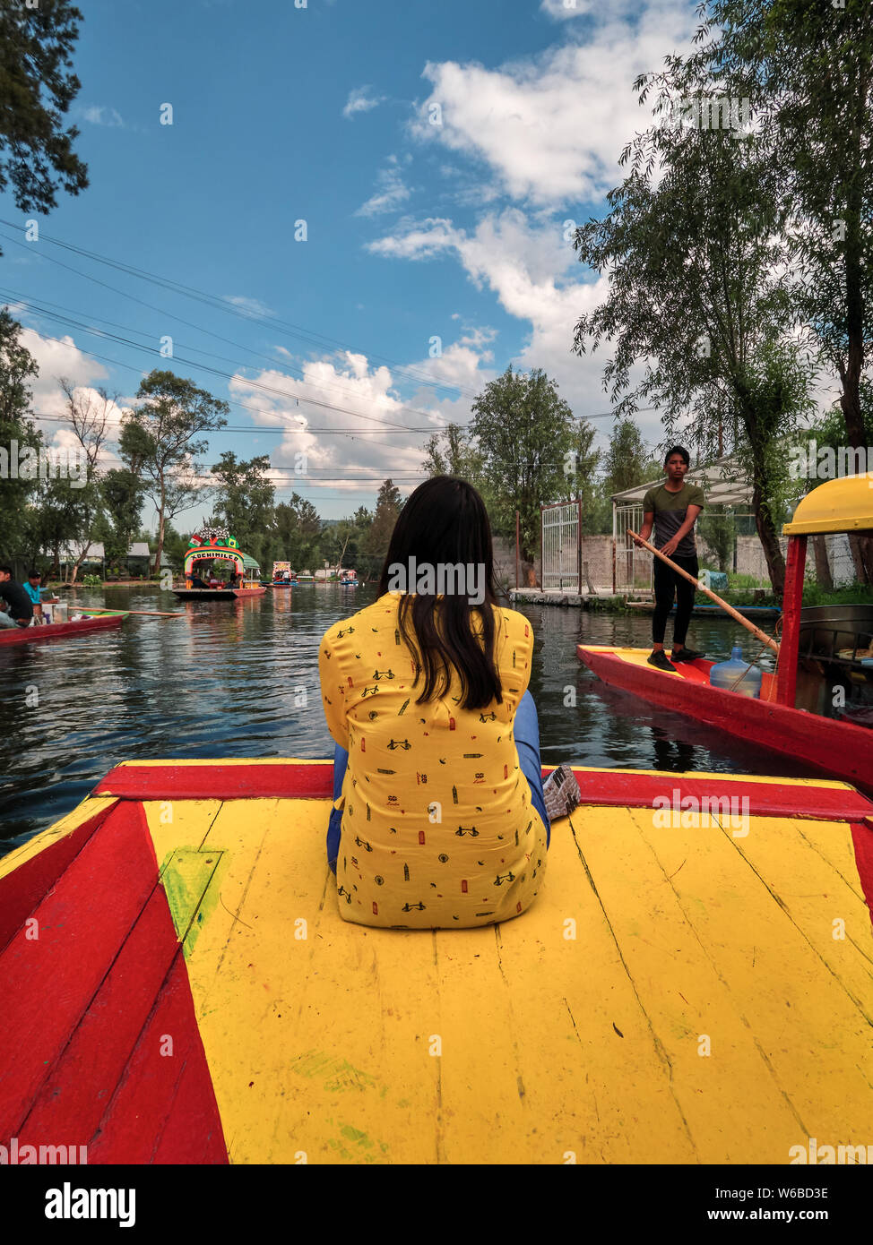 Xochimilco, Mexico City, June 25, 2019 - Young latin woman sitting on the bow of traditional Xochimilco boat during the tour. Stock Photo