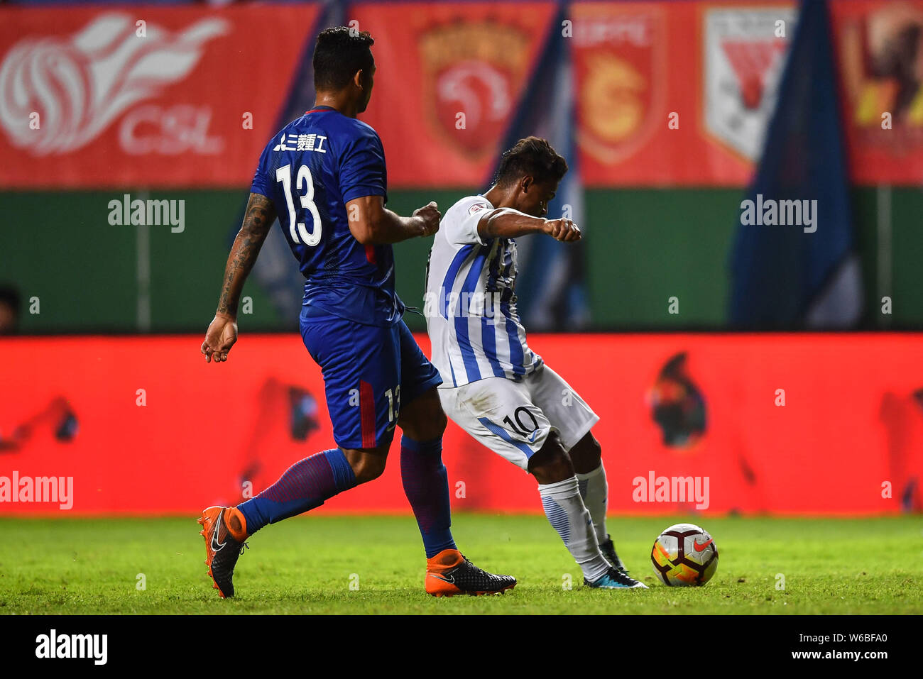 Brazilian football player Renatinho of Guangzhou R&F, right, challenges Colombian football player Fredy Guarin of Shanghai Greenland Shenhua in their Stock Photo