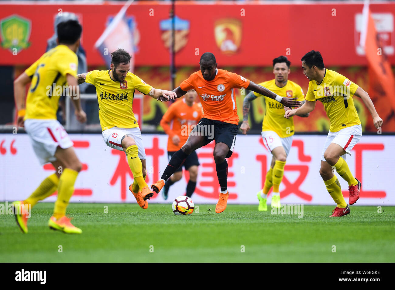 Ecuadorian football player Jaime Ayovi, center, of Beijing Renhe kicks the ball to make a pass against players of Guangzhou Evergrande Taobao in their Stock Photo
