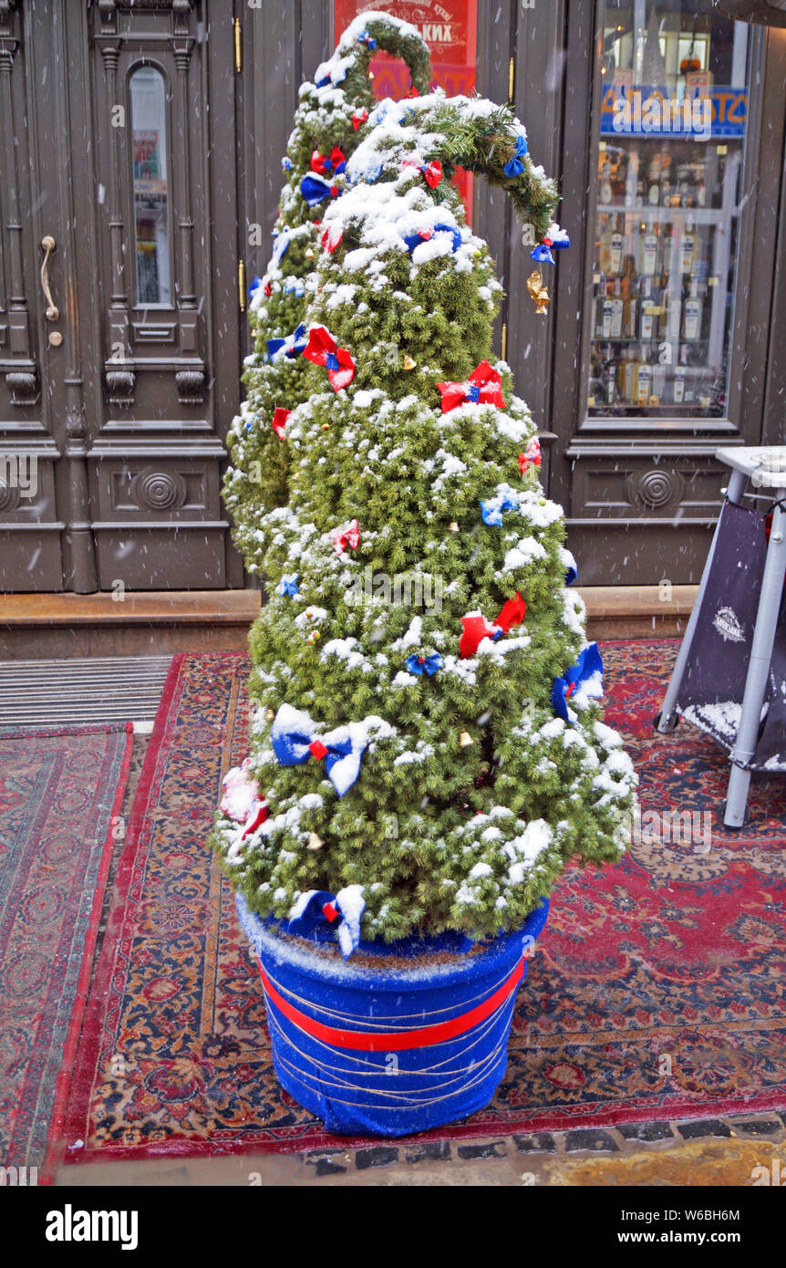 Christmas tree decorated with festive balls and garlands stands on a ...
