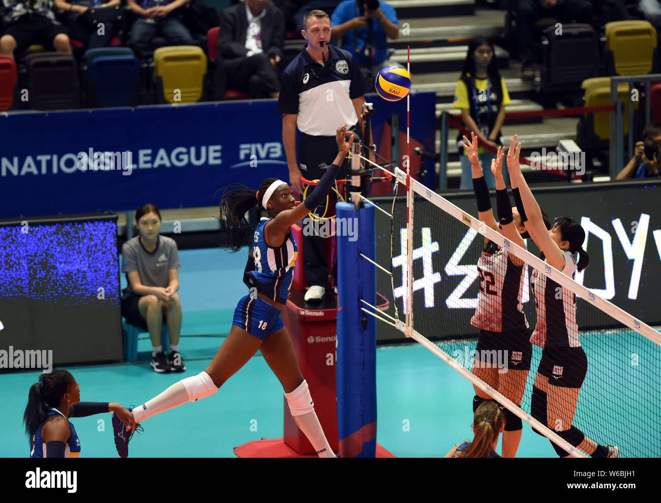 Paola Ogechi Egonu, top, of Italy spikes against Kanami Tashiro of