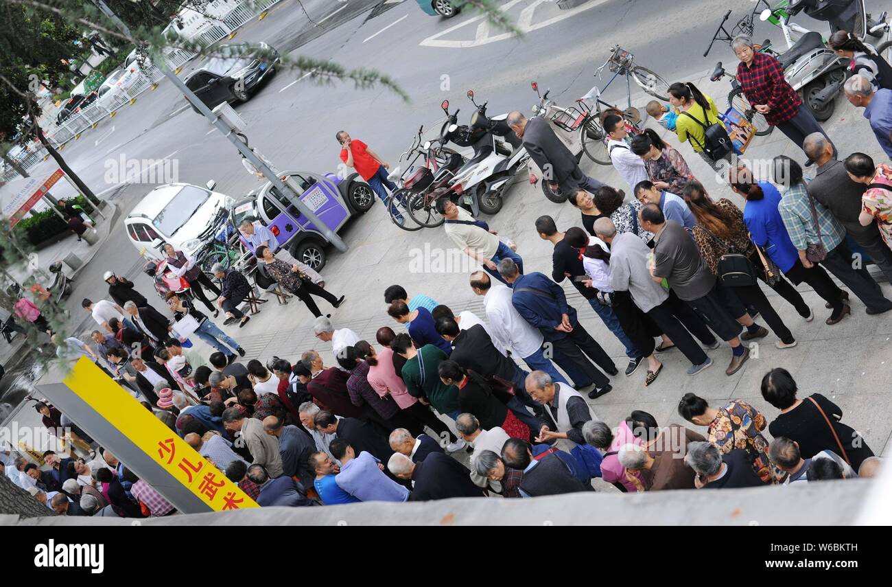 Local Chinese residents queue up in front of a branch of China Gas to ...