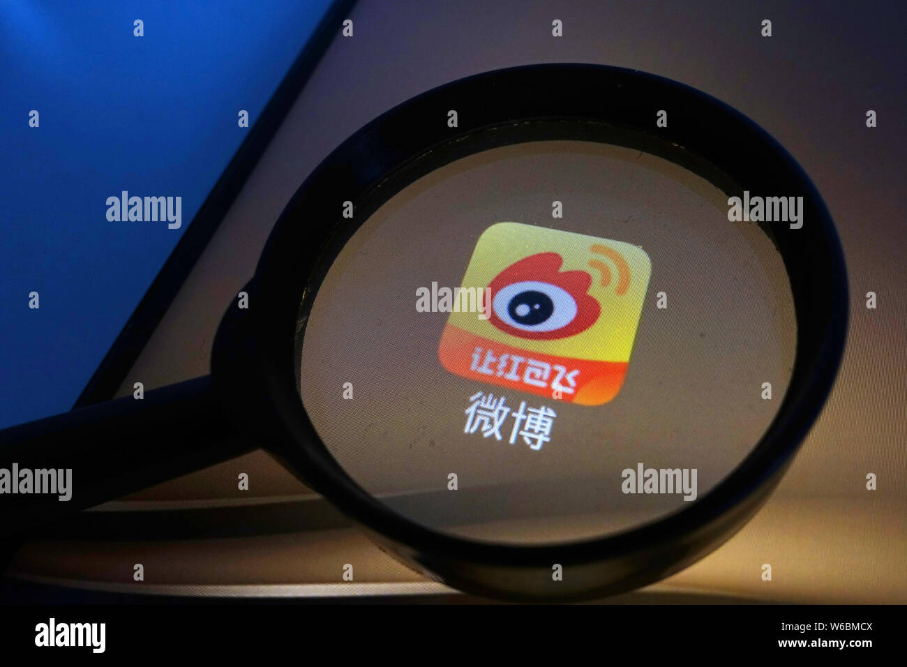 --FILE--A Chinese netizen looks at a logo of Weibo, the Twitter-like microblogging service of Chinese Internet portal Sina, on his smartphone in Ji'na Stock Photo
